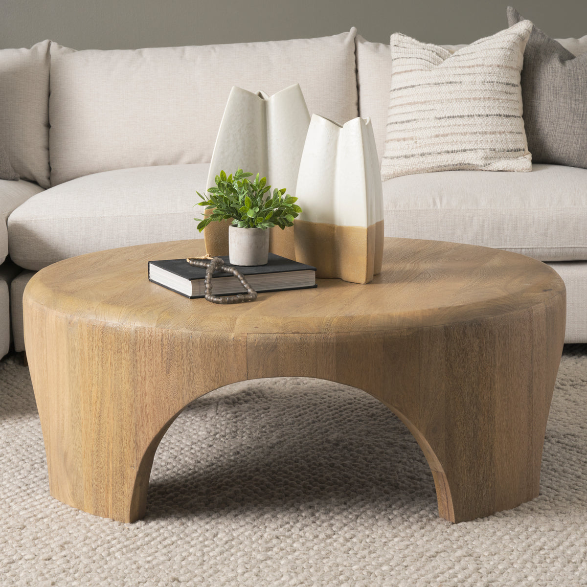 Shima round coffee table styled in a living room with a cream sofa