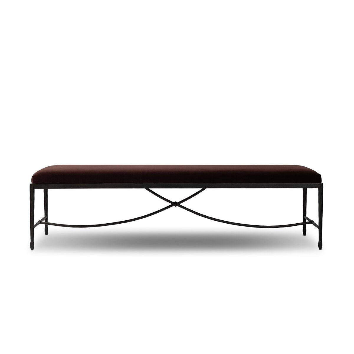 Four Hands Jade Accent Bench in Surrey Plum, a deep aubergine velvet-like seat on a curved bronzed hammered iron base